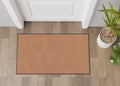 Blank brown door mat on the floor at home. Welcome mat with copy space for your text. Doormat mock up. Carpet at