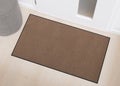 Blank brown door mat on wooden floor, perfect for showcasing custom designs or logos in an urban home setting. Welcome Royalty Free Stock Photo