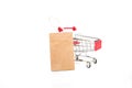 Blank brown paper shopping bag with new red shopping cart isolate on white background Royalty Free Stock Photo