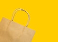 Blank brown paper shopping bag on yellow background. Spring Easter sale gift buying for holidays Royalty Free Stock Photo