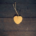 Blank brown tag heart shape on old wood background Royalty Free Stock Photo