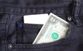 Blank business card and two dollar in a pocket of gry worn out jeans. Royalty Free Stock Photo