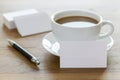 Blank business cards, pen and cup of coffee on wooden table. Royalty Free Stock Photo