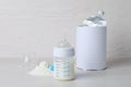 Blank can of powdered infant formula with scoop and feeding bottle on white wooden table. Baby milk Royalty Free Stock Photo