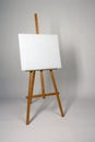 Blank canvas on Easel. Clean cloth stretched on subframe with copy space. Tripod for new oil painting. Empty white canvas for