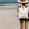 A blank canvas tote bag on a beach with customizable accessories2 Royalty Free Stock Photo