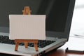 Blank canvas and wooden easel on laptop computer Royalty Free Stock Photo