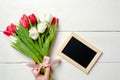 Blank card for invitation or congratulation with bunch of tulips flowers on white wooden table. Vintage banner mockup for spring h Royalty Free Stock Photo