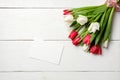 Blank card for invitation or congratulation with bunch of white tulips flowers on white wooden table. Vintage banner mockup for sp Royalty Free Stock Photo