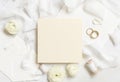 Blank card near cream roses, white silk ribbons and wedding rings top view, wedding mockup Royalty Free Stock Photo