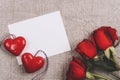 Blank card, two hearts and red roses on neutral textile background. Valentines day concept. Top view, flat lay, mockup Royalty Free Stock Photo