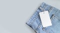Blank cardboard tag or label with rope on jeans clothes background Royalty Free Stock Photo