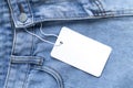 Blank cardboard tag or label with rope on jeans clothes background Royalty Free Stock Photo