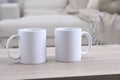 Blank ceramic mugs on white wooden table. Mockup for design Royalty Free Stock Photo