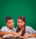 Blank Chalk Board Behind Hispanic Boy and Girl Having Fun Studying Royalty Free Stock Photo