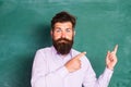 Blank chalkboard with copy space. Portrait of a funny teacher or professor near blackboard. Thinking serious mature Royalty Free Stock Photo