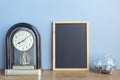 Blank chalkboard and old vintage clock standing on wood table. space for text, Home decoration Royalty Free Stock Photo