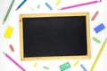Blank chalkboard in wooden frame with art supplies on white background. Blackboard flat lay photo. Royalty Free Stock Photo