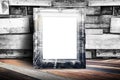 Blank city overlay vintage photo frame leaning at plank wood wall and diagonal wood floor,Mock up for adding your design Royalty Free Stock Photo