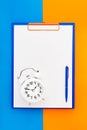 Blank clipboard mock-up, a blue pen and white alarm clock on the blue-orange color background. Top view, copy space. Back to Royalty Free Stock Photo