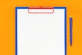 Blank clipboard mockup and blue pen on orange color background. Top view, copy space. Back to school, deadline, morning concept Royalty Free Stock Photo