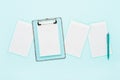 Blank clipboard mockup, empty paper sheets, and ballpoint pen on light blue color background. Top view, copy space. Back to school Royalty Free Stock Photo