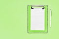 Blank clipboard mockup and white ballpoint pen on green color background. Top view, copy space. Back to school, deadline, morning Royalty Free Stock Photo