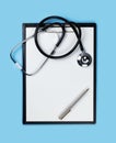 Blank clipboard with stethoscope on blue background Royalty Free Stock Photo
