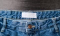 Blank clothing label on denim jeans texture. Label with empty space for text Royalty Free Stock Photo