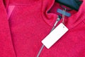 Blank clothing label tag on a red jacket Royalty Free Stock Photo