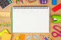 Blank notebook with school supplies frame against a wood desk background with copy space. Back to school. Royalty Free Stock Photo