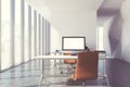 Blank computer monitor on a white table in a panoramic office.