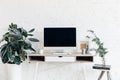 Blank copmuter screen on workplace surrounded with flower pots Royalty Free Stock Photo