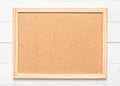 Blank cork board with corkboard texture background with wooden frame hanging on white wood wall for bullentin, memo or noticeboard