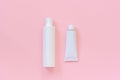 Blank cosmetic or medical white plastic bottle and tin tube for cream, shampoo, ointment, toothpaste or other product on pink Royalty Free Stock Photo