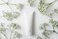 Blank Cosmetic Tube on Textured White Background with Natural Elements Royalty Free Stock Photo