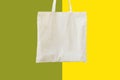 Blank cotton shite shopper tote bag on duotone green yellow background. Mock up template for product branding plastic free