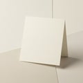 A blank cream-colored card stands on a similarly colored surface. The card is folded Royalty Free Stock Photo