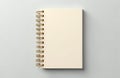Blank cream colored spiral bound notebook sits on neutral gray surface. Top view shows clean pages ready for writing ideas Royalty Free Stock Photo