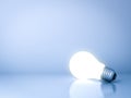 Blank creative idea background concept with one glowing idea light bulb on blue Royalty Free Stock Photo
