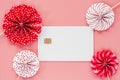 Blank credit chip card with red and white paper fan on pink back Royalty Free Stock Photo