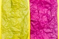 Blank crumpled purple and yellow sheets of colored paper on a yellow cardboard background. Textural motley background