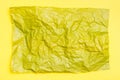 Blank crumpled yellow sheet of colored paper on a yellow cardboard background. Textural motley background. Top view