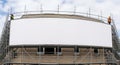 Blank Curved Billboard on Scaffolding with Construction Workers Royalty Free Stock Photo