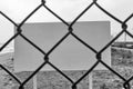 Blank danger or warning sign through wire mesh fence