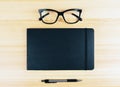 Blank diary cover with eyeglasses and pen on wooden table Royalty Free Stock Photo