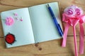 Blank diary notebook, pink flower, watch and pen on wooden table Royalty Free Stock Photo