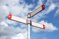 Blank directional road signs against a blue sky with clouds Royalty Free Stock Photo