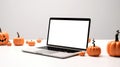 Blank display screen laptop computer on white wood table with Halloween decor. Home office desk workspace. Mock up copy space. Royalty Free Stock Photo