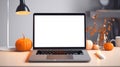 Blank display screen laptop computer on white wood table with Halloween decor. Home office desk workspace. Mock up copy space. Royalty Free Stock Photo